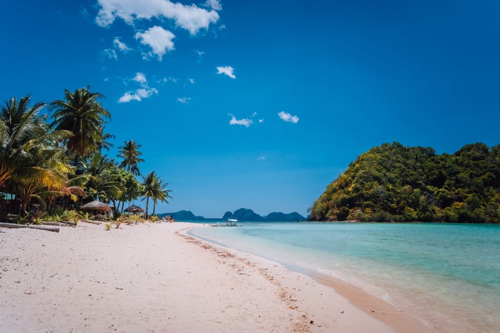 El Nido, Palawan, Philippines. Shallow lagoon, sandy beach with palm trees. Travel and vacation