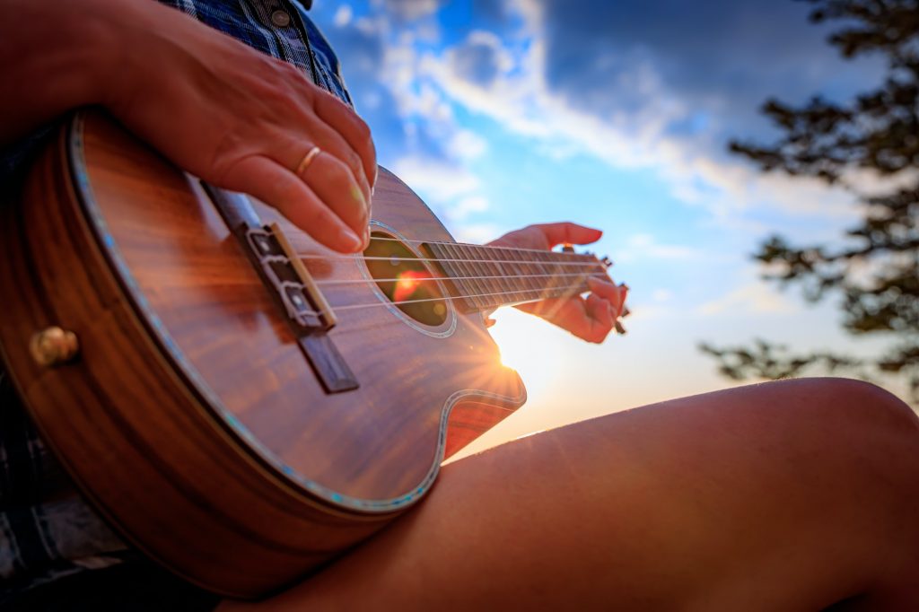 Woman at sunset holding a ukulele